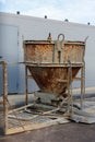A rusty bucket is sitting on a concrete slab