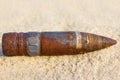 Rusty bullet lie on a sand background