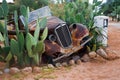 Rusty car as garden decoration between cacti in Namibia