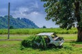 Rusty car wreck, Derelict old car is overgrown with grass, An old rusted out scrap car that has been abandoned mountains under th