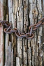 A rusty chain on the background of an aged wooden board. Royalty Free Stock Photo
