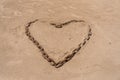 Rusty chain formed in shape of a heart on a sandy beach Royalty Free Stock Photo