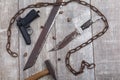 Rusty chain with a gun on a wooden background. View from above
