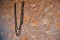 Rusty chain hanging on the stone wall Royalty Free Stock Photo