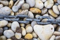 Rusty chain laid on pebbles, Chesil beach, Weymouth, Dorset Royalty Free Stock Photo