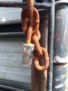 rusty chain with padlock key dangling turnstile fastener accentuates a firmer texture Royalty Free Stock Photo