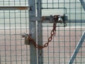 Rusty chain and padlock on metal fence Royalty Free Stock Photo