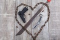 Rusty chain in the shape of heart and machete close-up on a wooden background. View from above