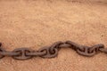 Rusty chains. Selective focus on a old big rusty ships anchor chain in the sand near the sea with large copy space. Abstract Royalty Free Stock Photo