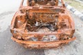 Rusty chassis of a burnt car abandoned by the side of the street Royalty Free Stock Photo