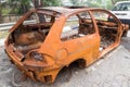 Rusty chassis of a burnt car abandoned by the side of the street Royalty Free Stock Photo