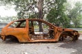 Rusty chassis of a burnt car abandoned by the side of the street Royalty Free Stock Photo