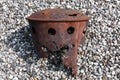 Rusty chimney on a bunch of grey beach pebble stones