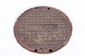 Rusty circular utility electric manhole cover amid fresh white snow in winter Royalty Free Stock Photo