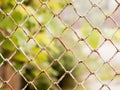 Rusty colored mesh netting. The metal fence