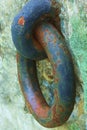 Rusty colorful harbor chain attached to cement block.