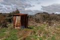 A rusty corrugated iron back country toilet or outhouse