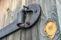 Rusty door hinge with pulled out nails on old wooden doors Royalty Free Stock Photo