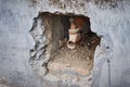 Rusty faucet in a hole in a concrete wall. Stones and debris in the technological deepening. Royalty Free Stock Photo