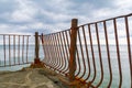 Rusty fence on the pier near the sea. Rest on black sea. Metal corrosion. Rusty metal fence surface. Royalty Free Stock Photo