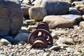 Rusty gear from old shipwreck along rock covered beach at Gros Morne