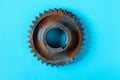 Rusty gear wheel made of chocolate isolated on blue background