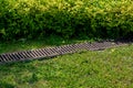 Rusty grate drainage system on lawn. Royalty Free Stock Photo