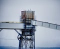 A rusty, grungy silo at a wharf against a gray sky. Taken in Seattle, Washington.