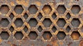Rusty hexagonal metal grate with weathered texture and irregular openings