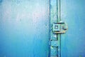 Rusty hinges on old iron door with a shabby turquoise blue, green paint Royalty Free Stock Photo