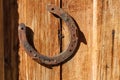 Rusty horseshoe on old wooden background. Outdoors image on a sunny day Royalty Free Stock Photo