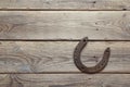 Rusty horseshoe on old wooden board. Royalty Free Stock Photo