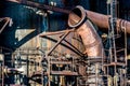 Rusty industrial pipes and metal structures casting shadows on a factory wall Royalty Free Stock Photo