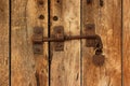 Rusty iron bolt and padlock on old wooden door Royalty Free Stock Photo