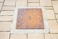 Rusty iron cast manholes in a modern stone paving Royalty Free Stock Photo