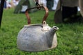 Rusty kettle hanging on chain