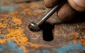 A rusty keyhole is being probed by a weathered metal key, highlighting the textures of age and decay Royalty Free Stock Photo