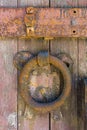 Rusty knocker and bolt on an old wooden door. Old paint and wood texture are visible Royalty Free Stock Photo