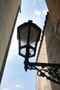 A rusty lamp on a wall in narrowest Prague street. Royalty Free Stock Photo