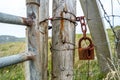 Rusty lock and chain hanging at fence next to gate Royalty Free Stock Photo