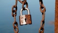 Rusty lock hanging on an old chain