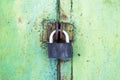 rusty lock on a texture of old, metal, iron, Green, celadon door, which the old paint flaking. locked. place for text. Royalty Free Stock Photo