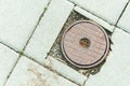 Rusty manhole cover of access point for a shut off valve to a water main along a sidewalk. Royalty Free Stock Photo