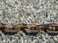 rusty metal anchor chain on coast pebble stones . Royalty Free Stock Photo