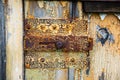 Rusty metal bolt and latch close-up on old shabby wooden door. Chunks of paint, peeling paint, corrosion of metal, Rusty metal. Royalty Free Stock Photo