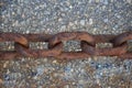 Rusty metal chains on the background of stones