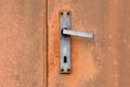 Rusty metal door and aluminium door handle detail Royalty Free Stock Photo