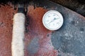 Rusty metal door of a stone oven with heat thermometer
