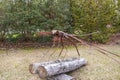 A rusty metal dragonfly sculpture surrounded by lush green trees and plants at Atlanta Botanical Gardens in Gainesville Georgia