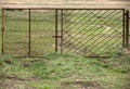 A rusty metal gate in a meadow